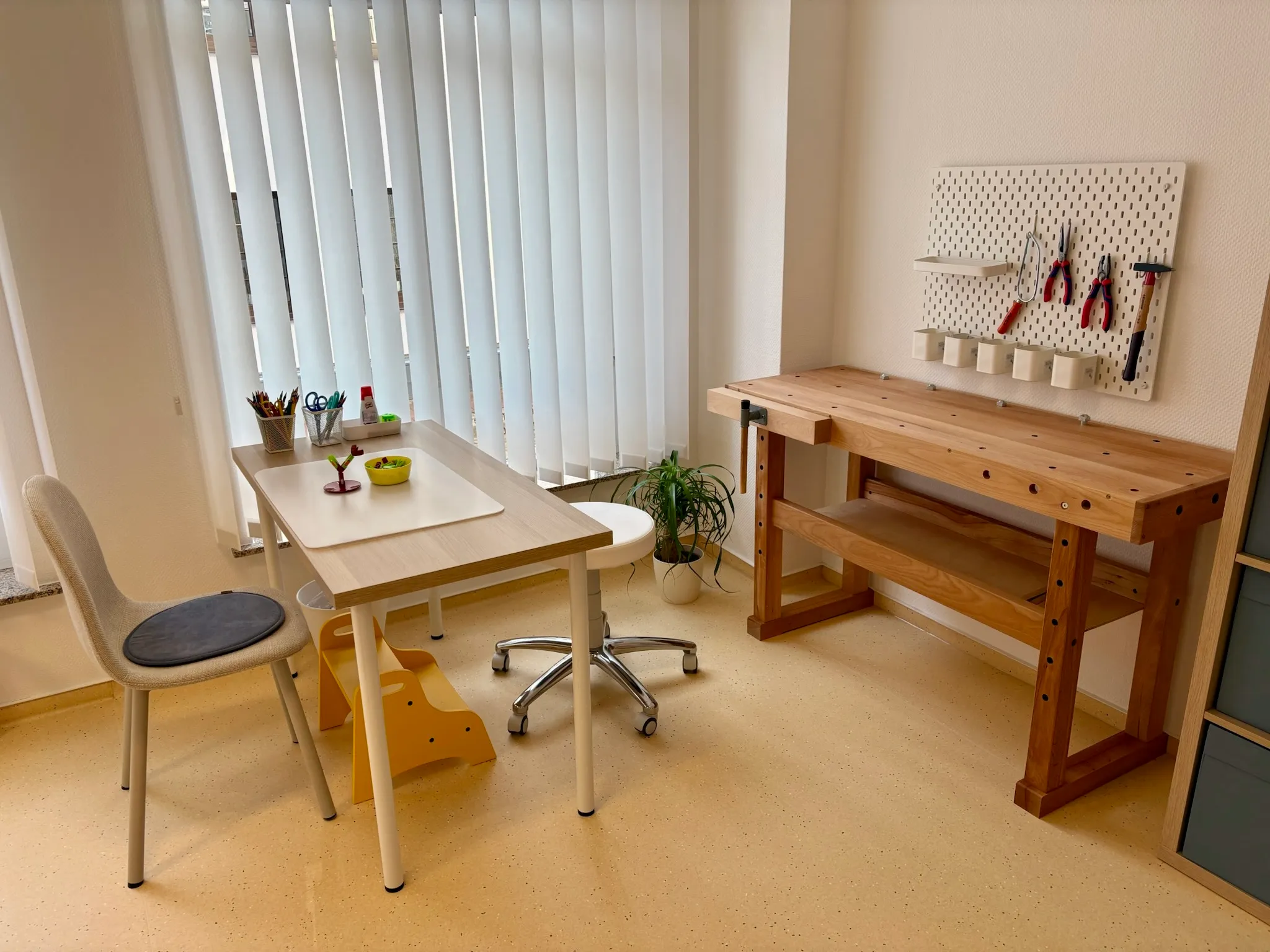 Werkraum mit höhenverstellbarem Therapietisch, Stühlen und Hobelbank