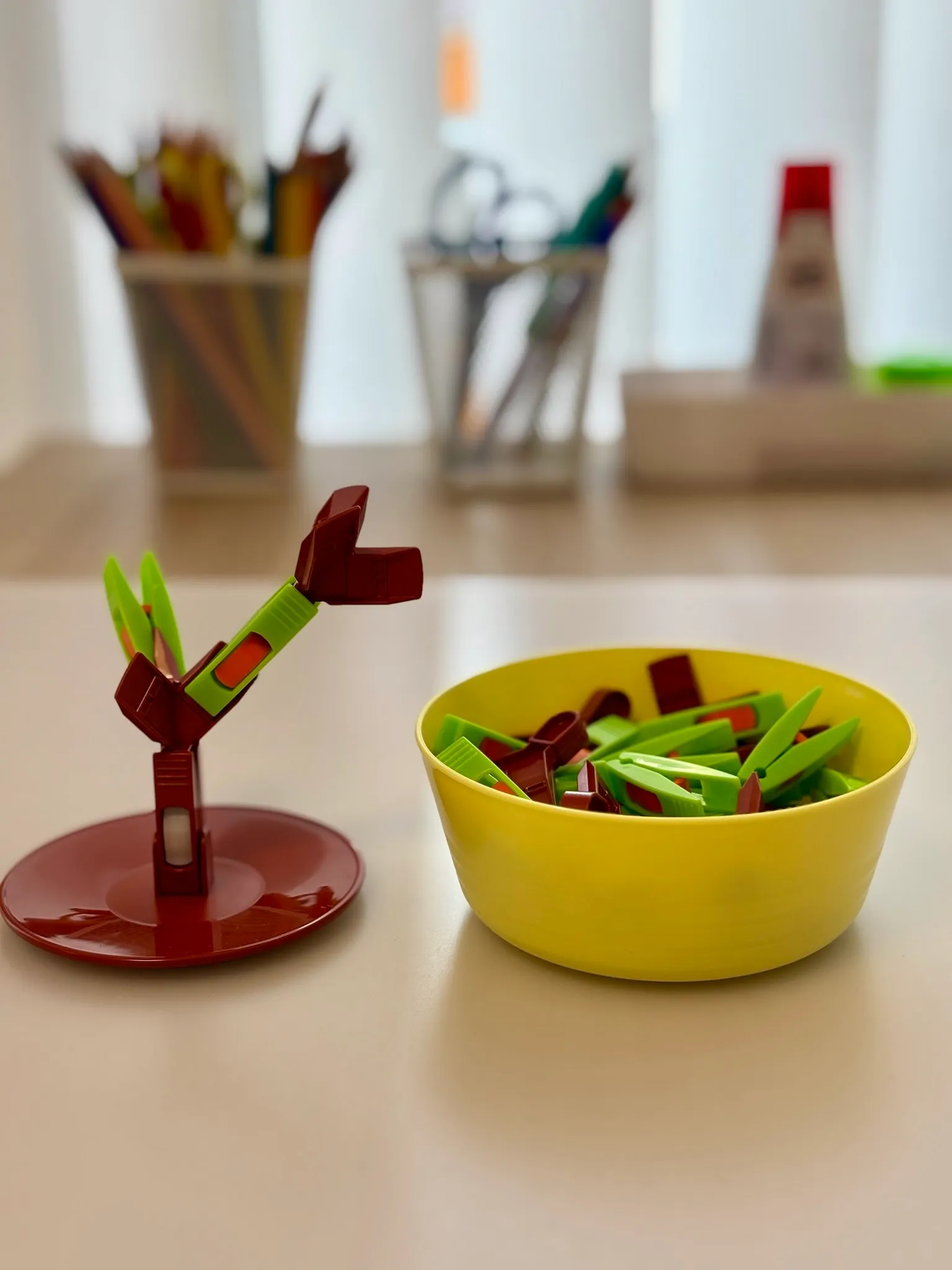 Therapietisch mit Klammer-Steckspiel, Stiften und Scheren im Hintergrund
