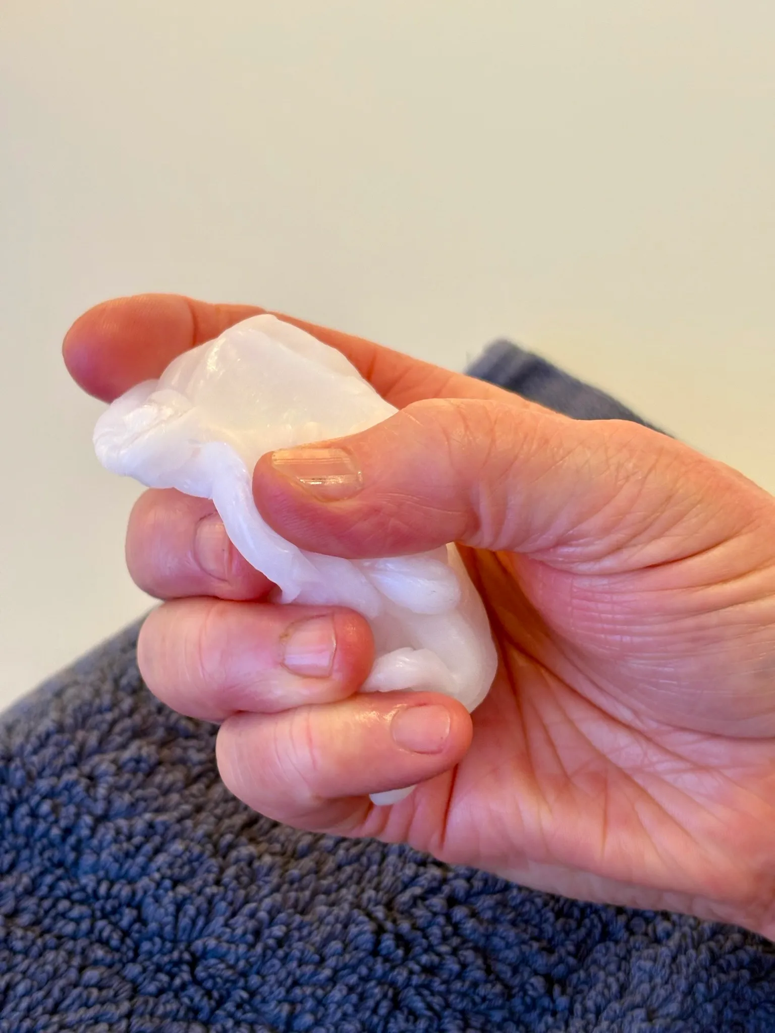 Hand knetet weiße Therapieknete zur Kräftigung der Finger